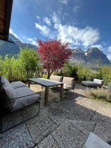 上特勞恩的住宿－Chalet Obertraun，一个带桌子和两把椅子的庭院和山脉