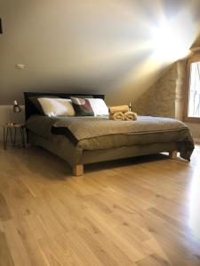 Bett in einem Schlafzimmer mit Holzboden in der Unterkunft Maison Puchouaou Chambres d'Hôtes sur le chemin de Saint jacques de Compostelle in Montesquiou