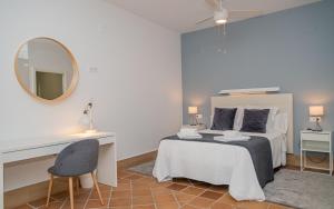 a bedroom with a bed and a desk and a mirror at Apartamentos Casa Tuli B, ALJARAQUE in Aljaraque