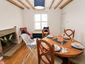 Bradley House في ماتلوك: غرفة طعام مع طاولة وكراسي ومدفأة