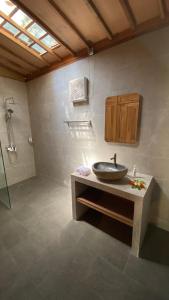 y baño con lavabo y ducha. en Villa Lova Sambirenteng, en Gretek