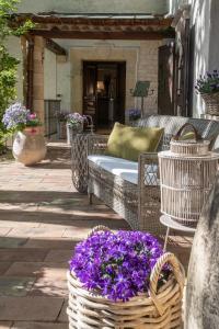 a basket of purple flowers sitting on a patio at Hotel Les Messugues in Saint Paul de Vence