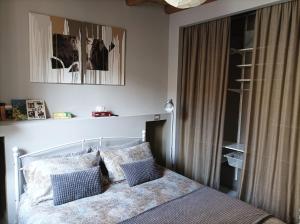 Schlafzimmer mit einem Bett mit blauen und weißen Kissen in der Unterkunft La contrada in Cuneo