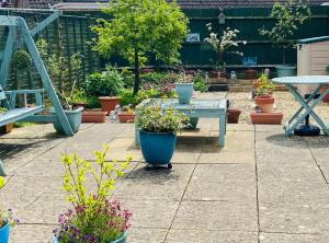 a patio with a table and potted plants on it at A single-bed room with a guest lounge in Cheltenham