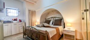 um quarto com uma cama com um arco por cima em Il trullo felice em Locorotondo