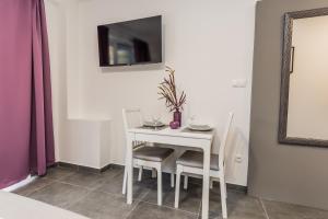 tavolo bianco con sedie e TV a parete di Studio Apartment Kastel Star a Kaštela (Castelli)