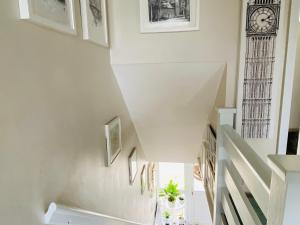 a staircase in a house with a clock on the wall at A single-bed room with a guest lounge in Cheltenham