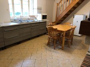 eine Küche mit einem Holztisch und einem Waschbecken in der Unterkunft Petite maison spacieuse in Billy