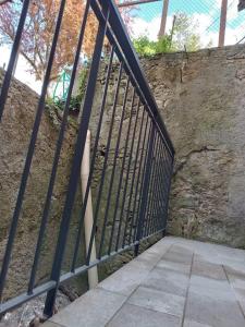 una puerta de hierro negra junto a una pared de piedra en 44 Ricci, en Anghiari