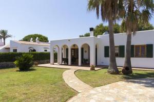 a white house with palm trees in front of it at VILLA SAVINA in Cala en Blanes