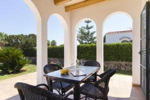 a table and chairs on a patio with a view at VILLA SAVINA in Cala en Blanes