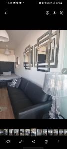 a living room with a couch and two mirrors at Tampere City studio Areena in Tampere