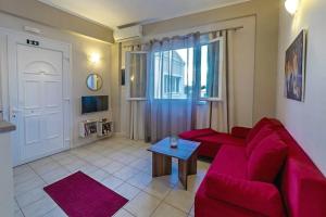 a living room with a red couch and a table at Corfu Stinados Apartment in Ermones
