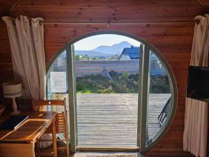 una porta aperta su un ponte in una cabina con tavolo e panca di The Hobbit House on the Isle of Skye a Breakish