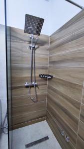 a shower with a light on top of a wooden wall at Elvish Garden Boutique B&B in Berat