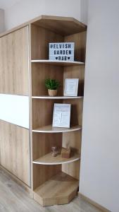 a wooden book shelf with a sign on it at Elvish Garden Boutique B&B in Berat