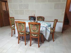 une table à manger avec quatre chaises et un tissu de table dans l'établissement Grande maison bucolique Beauval Châteaux, à Saint-Romain-sur-Cher