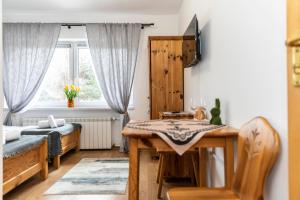 a bedroom with a desk and a bed and a window at Pokoje Gościnne Góraleczka Kościelisko in Kościelisko