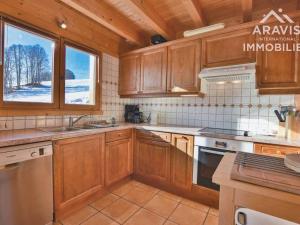 a kitchen with wooden cabinets and a stove top oven at Chalet Le Grand-Bornand, 7 pièces, 12 personnes - FR-1-391-30 in Le Grand-Bornand