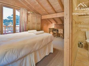 een slaapkamer met een bed en een bureau in een kamer bij Chalet Le Grand-Bornand, 7 pièces, 12 personnes - FR-1-391-30 in Le Grand-Bornand