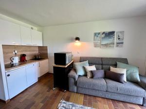 ein Wohnzimmer mit Couch und Küche in der Unterkunft La Madrague in Saint-Cyr-sur-Mer