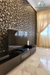 a living room with a large television and a wall with a pattern at 99 Kelawei in George Town