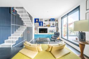 - un salon avec un canapé jaune et des escaliers dans l'établissement Maison+jardin, 25' Paris Expo, Paris Centre & Orly, à Bagneux