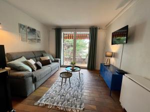 ein Wohnzimmer mit Sofa und Tisch in der Unterkunft La Madrague in Saint-Cyr-sur-Mer