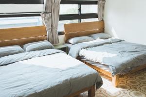 的住宿－鴉埠客棧x南華大旅社，一间卧室设有两张床和窗户。