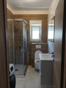 uma casa de banho com um chuveiro, um WC e um lavatório. em Apartment Gloria em Zadar