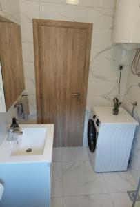 uma casa de banho com uma máquina de lavar roupa e um lavatório em Apartment Gloria em Zadar