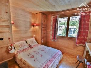 um quarto com uma cama num quarto de madeira em Appartement Le Grand-Bornand, 4 pièces, 6 personnes - FR-1-391-86 em Le Grand-Bornand
