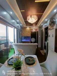ein Wohnzimmer mit einem Kronleuchter und einem Tisch im Zimmer in der Unterkunft 2 BR luxury type Condo Unit in Manila