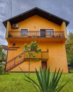 a yellow building with a balcony on it at Apartman Jovičić in Višegrad