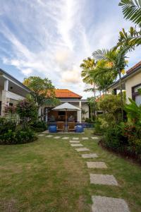 einen Garten mit einem Weg, der zu einem Haus führt in der Unterkunft Villa Katara in Seminyak