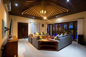 ein Wohnzimmer mit einer Couch und einem Tisch in der Unterkunft Villa Katara in Seminyak