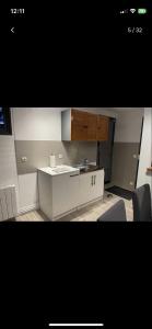 a kitchen with a white counter and wooden cabinets at Petite maison chaleureuse des boucles de la Seine in Le Mesnil-sous-Jumièges