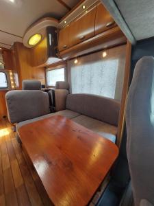 a living room with a wooden table and a couch at AutoVan IBZ in Sant Josep de sa Talaia