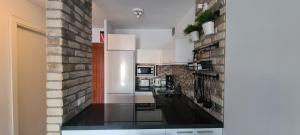 a kitchen with white appliances and a brick wall at Torres del Sol-La Perla ocean view in Los Cristianos