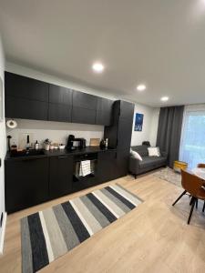 uma cozinha com armários pretos e uma sala de estar em Kärdla Holiday Apartment with Sauna and Terrace em Kärdla