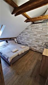 1 dormitorio con cama y pared de ladrillo en Lake House Siófok en Siófok