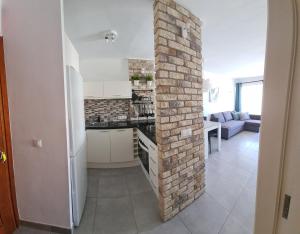 a kitchen and living room with a brick wall at Torres del Sol-La Perla ocean view in Los Cristianos