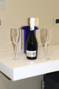een fles wijn en twee wijnglazen op een plank bij Hotel Diamante in Cattolica