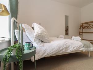 Un dormitorio con una cama y una mesa con una planta en The Lookout en Penzance