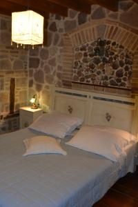 two beds in a room with a stone wall at Lesvos Tower House Komninos in Sígrion