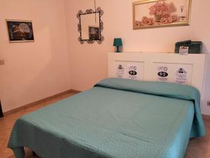 ein Schlafzimmer mit einem Bett mit einer grünen Decke in der Unterkunft La Perla B & B in Ciampino