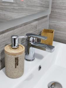 - un lavabo dans la salle de bains avec un distributeur de savon dans l'établissement Elvish Garden Boutique B&B, à Berat