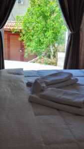 Una cama con tres toallas encima. en Elvish Garden Boutique B&B, en Berat
