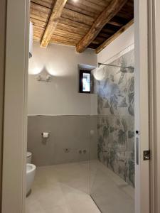 a bathroom with a glass shower with a toilet at Borgo Lizori Country House in Campello sul Clitunno
