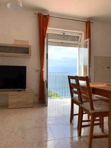 Sala de estar con mesa y vistas al océano en Casa Colomba Sant'Angelo, en Isquia